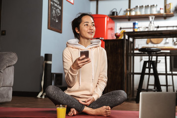 Sticker - Happy healthy woman sitting on a fitness mat