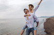 © Mediteraneo - Happy couple in love on beach summer vacations. Joyful girl piggybacking on young boyfriend having fun.
