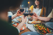 Happy friends enjoying healthy food drinking red wine and making cheers at home, Group of people celebrating together in cozy atmosphere, Dinner Family Friendship Holidays Concept