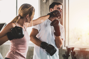 Sporty woman and men with the back boxing gloves training at the gym