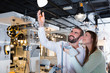 © JackF - Smiling couple customers choosing floor lamp in store