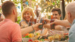 © Gorodenkoff - Family and Friends Gathered Together at the Table Raise Glasses and Bottles To Make a Toast and Clink Glasses. Big Family Garden Party Celebration.