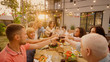 © Gorodenkoff - Family and Friends Gathered Together at the Table Raise Glasses and Bottles To Make a Toast and Clink Glasses. Big Family Garden Party Celebration.