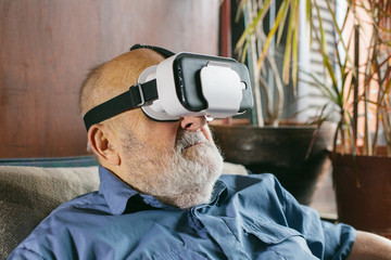 retired elderly man looking through VR goggles