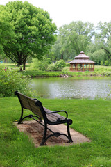 Wall Mural - midwest nature background with city park view. beautiful late spring landscape with bench in a foreg