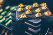 Strawberry, pineapple, cheese snacks with almonds on black slate in a buffet. Event catering concept.