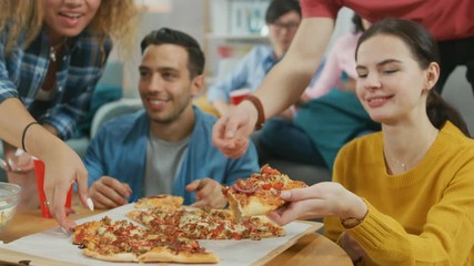 Wall Mural - At Home Diverse Group Friends Watching TV Together, They Share Gigantic Pizza, Eating Tasty Pie Pieces. Guys and Girls Watching Comedy Sitcom or a Movie, Laughing and Having Fun Together.