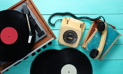 Wall Mural - Vinyl player, rotary phone, vinyl plates, old books. Old-fashioned objects on a blue wooden background. Retro style, 70s. Top view.