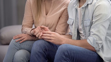 Couple Holding Hands, Sitting In Waiting Hall Hospital, Fertility Consultation