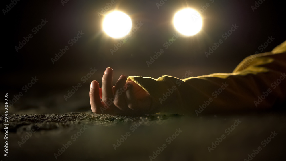 Car headlighting unconscious victim, lying on road after accident, crime - obrazy, fototapety, plakaty 