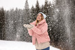 © New Africa - Young woman in warm clothes catching snow outdoors. Winter vacation