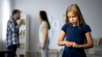 Wall Mural - Frightened girl nervously twisting fingers, scared by parents quarrel, violence