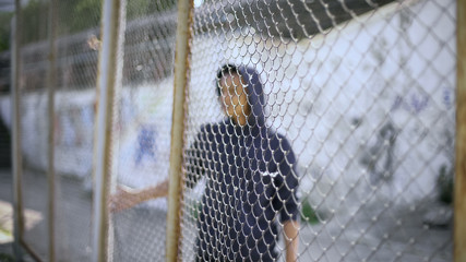 afro-american boy behind fence, migrant child separated from family, detained