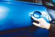 © hedgehog94 - Car wrapping specialist putting vinyl foil or film on car. Selective focus.