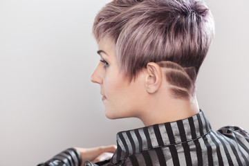 Portrait of a beautiful blonde woman with beautiful make-up and short haircut after dyeing hair in a hairdressing salon.