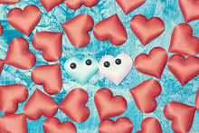 In The Center Of The Deep Blue Background, There Are Two Hearts With Doll Eyes. A Lot Of Red Rag Hearts Are Laid Out Around It. Symbol Of Love.