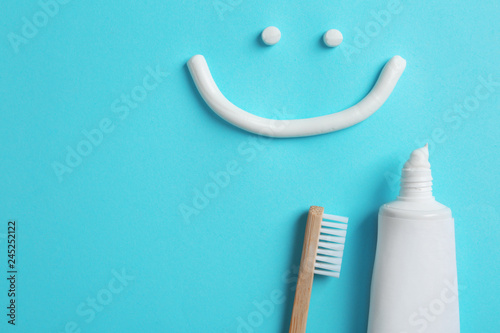 Fotografía Smiling face made of toothpaste, tube, brush and space for text on color backgro
