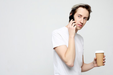  Portrait of happy man talking on phone and drinking coffee