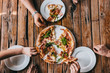 Hands grabbing pizza carbonara on rustic wooden table. Food photography concept. Top view