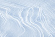 Winding lines from the wind in the snow. Texture of crusty snow. Winter background.