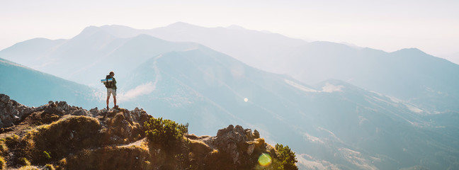 Mountain hiker with backpack tiny figurine stay on mountain peak with beautiful panorama