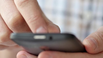 Close-up of hands holding smartphone, typing text on touch screen and using applications. A person typing message in social network and looking for information.