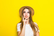 © dianagrytsku - Young pretty Woman thinking in straw hat on yellow background