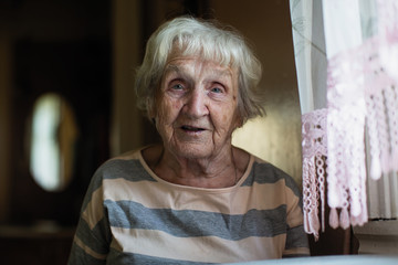 Wall Mural - Portrait of a pensioner russian woman at the table in home.