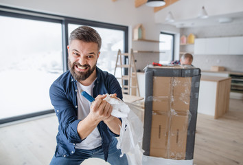 A mature man with his senior father furnishing new house, a new home concept.