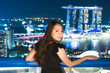 © siraphol - Beautiful Asian women smile and happy with singapore city view
