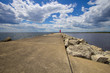 Manistique Michigan Lighthouse. Long pier with diminishing perspective under a sunny blue sky with lighthouse at the horizon.