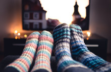 Cozy Woolen Socks. Couple Watching Tv In Winter. Man And Woman Using Online Streaming Service For Movies And Series. Relaxing Quality Time On Sofa Couch. People In Warm Home Living Room Enjoying Life.