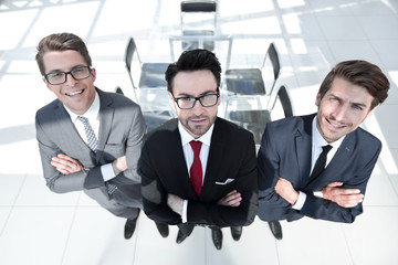 Wall Mural - three confident businessman on background of office