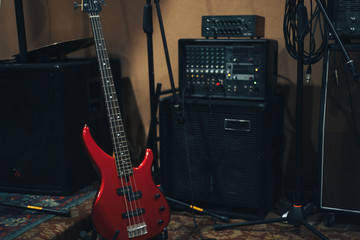 Poster - Red bass guitar on a home musical studio background.