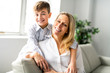 © Louis-Photo - A people and family happy boy with mother on sofa at home