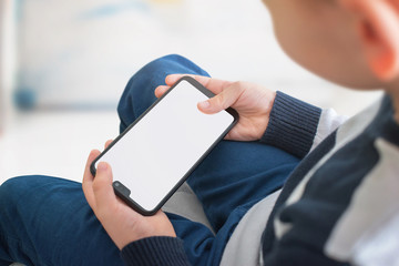 Leinwandbilder - Phone mockup in horizontal position in kid hands. Play game concept for app presentation.