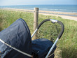 Baby pram looking out over dunes, beach and sea