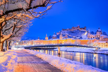 Salzburg, Austria: Winter Viewof The Historic City Of Salzburg With Famous Festung Hohensalzburg And Salzach River Illuminated In Beautiful Twilight During Scenic Christmas Time In Winter