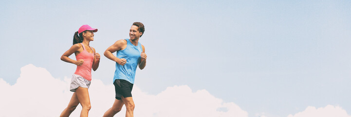 Healthy people fit active lifestyle couple running on sky background panoramic banner. Happy friends exercising together -training buddy.