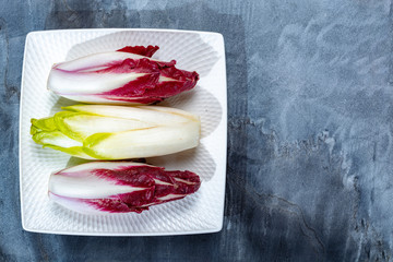 Food background, flat lay concept with fresh green Belgian endive or chicory and red Radicchio vegetables, also known as witlof