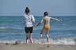 © TRINGA - Children, siblings playing on the sea shore. They jumping in the waves.