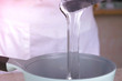 Cook pours the liquid glycerin into the saucepan to reheat. Close-up view.