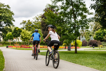 Wall Mural - Healthy lifestyle - people riding bicycles in city park