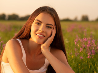 Beautiful young woman on nature over summer field background