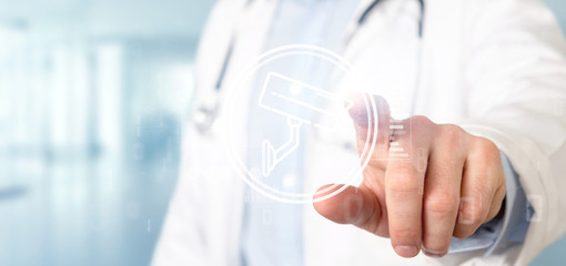 Poster - Doctor holding a Security camera system icon and statistics data - 3d rendering