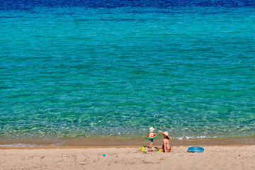 Toddler boy on beach with mother