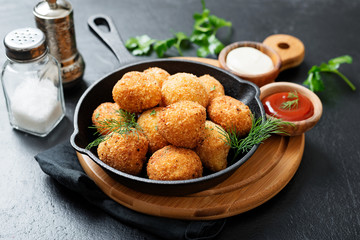 Wall Mural - Potato croquettes - mashed potatoes balls breaded and deep fried, served with different sauce.