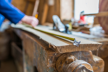 Sticker - Carpenter measuring a long oak board, focus on the ruler, shallow depth of field.