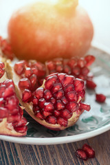 Wall Mural - Opened pomegranate with scattered seeds on the silver tray toned 2