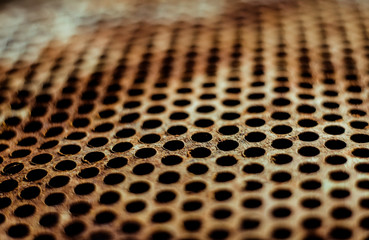 Wall Mural - Perforated brown rusty iron sheet texture. Surface of industrial mesh with depth of field. Horizontal corrosion grunge background